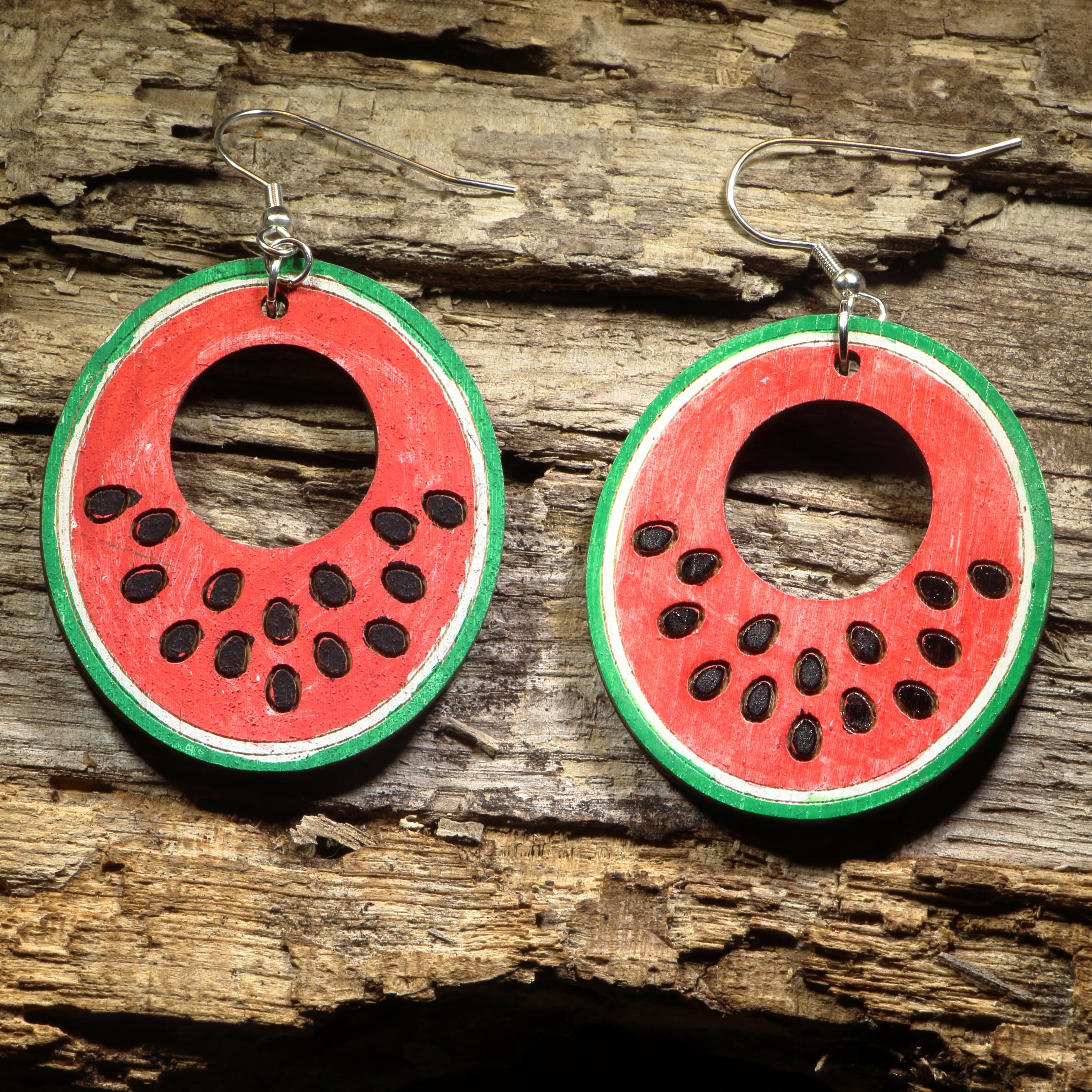 Hand-painted wooden watermelon slice hoop dangle earrings featuring juicy watermelon wedges with vibrant red, green, and black seed details. Crafted from lightweight wood with hypoallergenic .925 sterling silver hooks, these fun earrings are perfect for summer fashion, fruit lovers, picnics, farmers markets, beach vacations, and anyone who enjoys playful food-inspired jewelry.