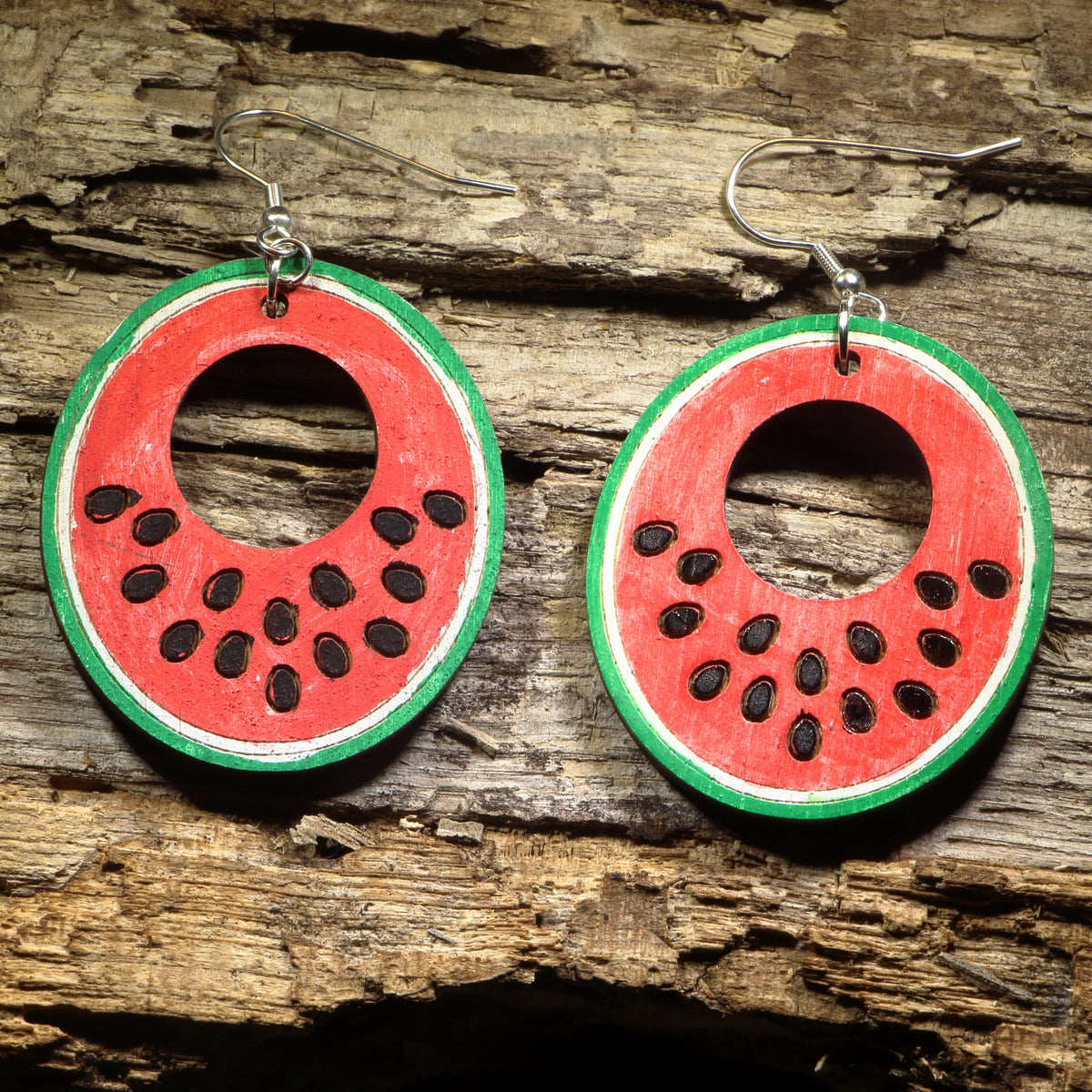Hand-painted wooden watermelon slice hoop dangle earrings featuring juicy watermelon wedges with vibrant red, green, and black seed details. Crafted from lightweight wood with hypoallergenic .925 sterling silver hooks, these fun earrings are perfect for summer fashion, fruit lovers, picnics, farmers markets, beach vacations, and anyone who enjoys playful food-inspired jewelry.