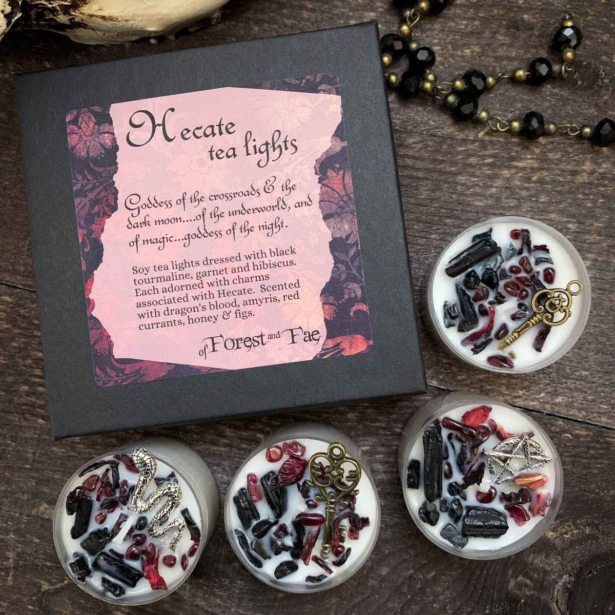 Hecate tea lights packaging with decorative tea lights on a wooden surface