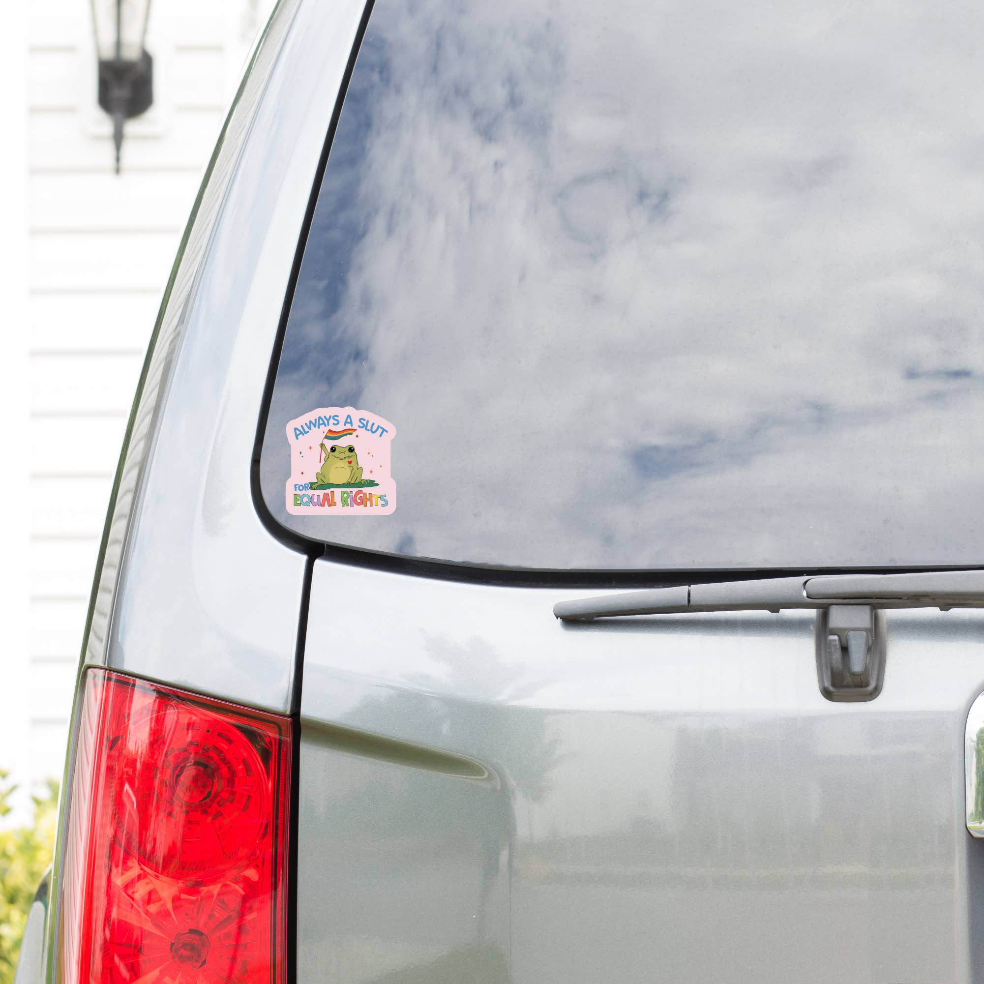 Car with a sticker on the rear window displaying cartoon characters with text &