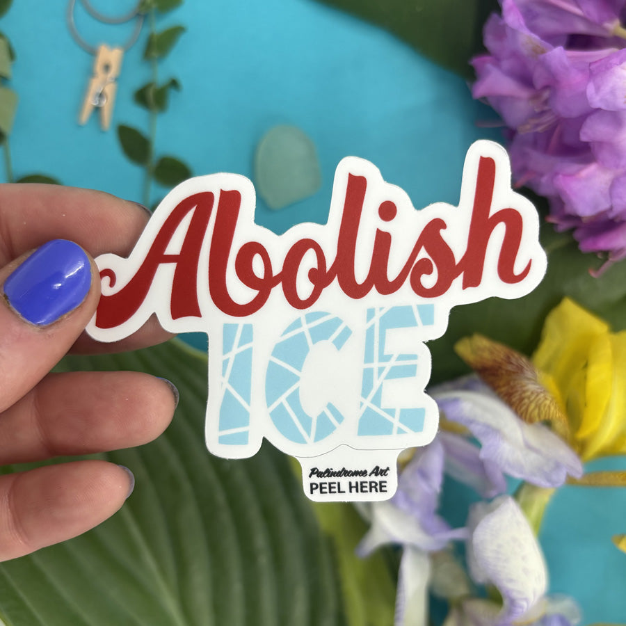 Hand holding a sticker with &