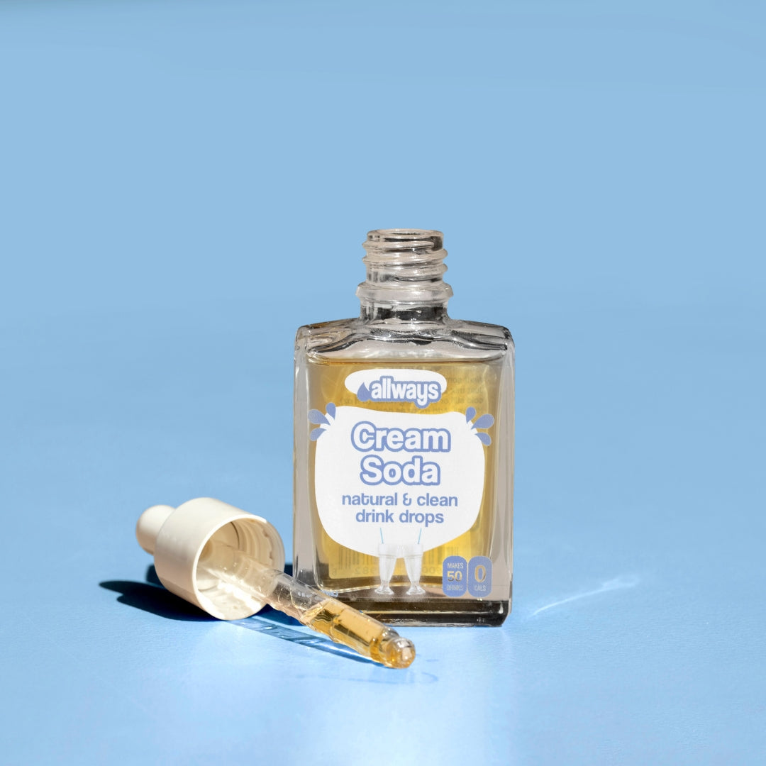 Allways cream soda drops with dropper laying next to glass bottle in front of a blue background