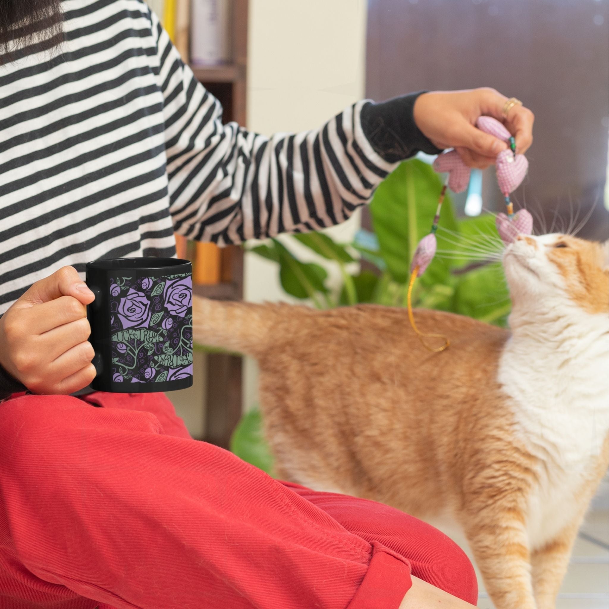 Woman with an orange cat holding Fuck Trump floral gothic coffee mug