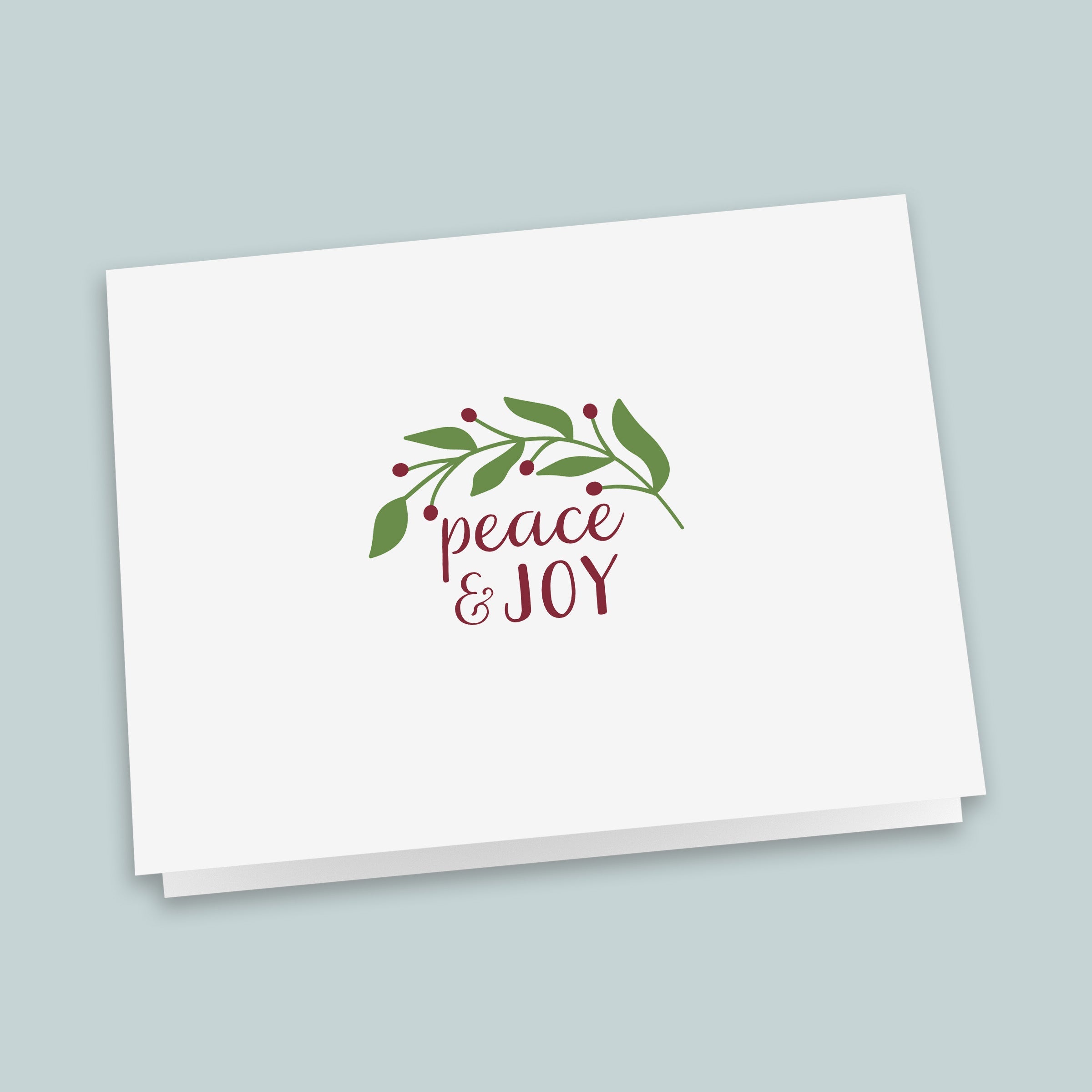 A white greeting card with a holiday-themed design and the text "Peace & Joy" printed on it.