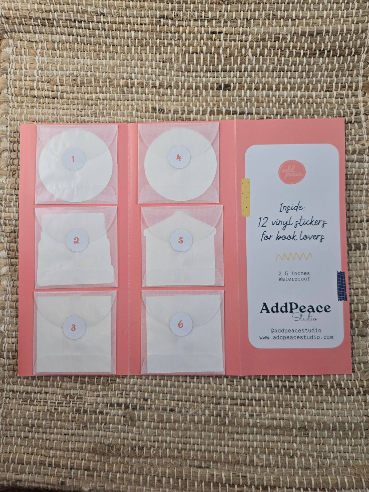 Pack of AddPeace vinyl stickers for book lovers on a textured surface