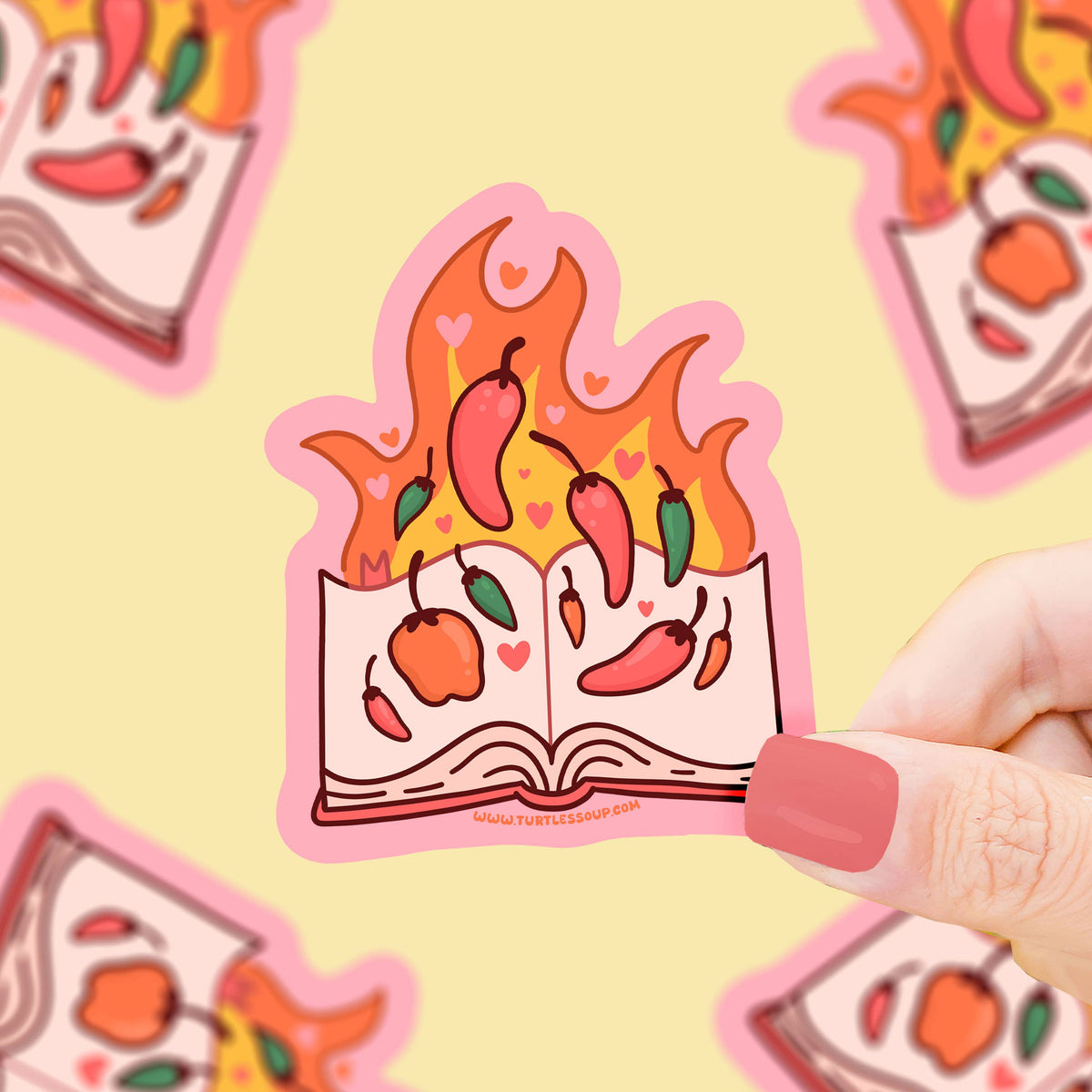 Sticker of an open book with chili peppers and apples held by a hand on a yellow background