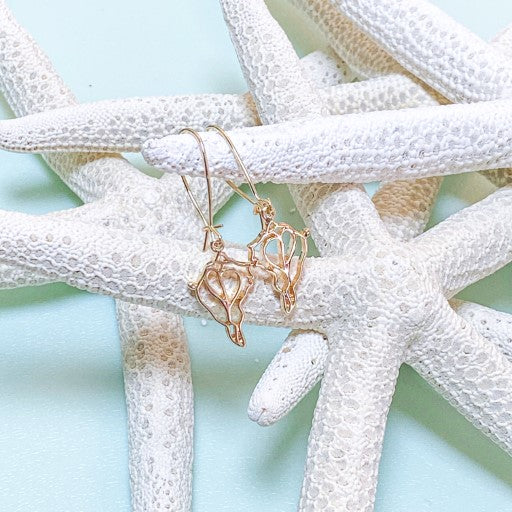 single drop gold conch shell earrings on loop wire on aqua background with white seastars