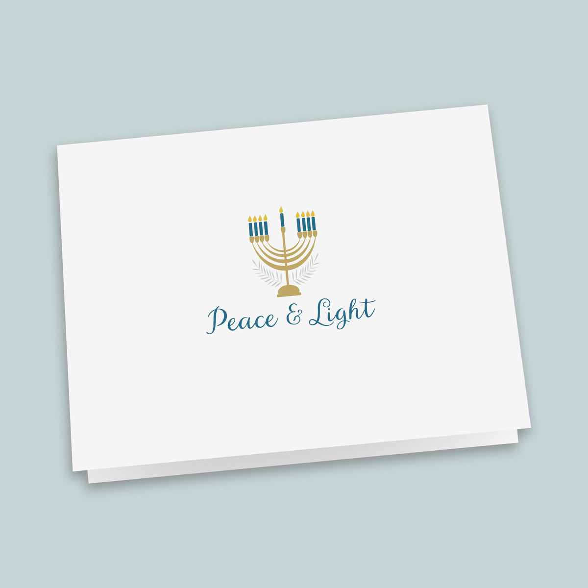 A white greeting card with a stylized graphic of a menorah and the text "Peace & Light" printed on it.