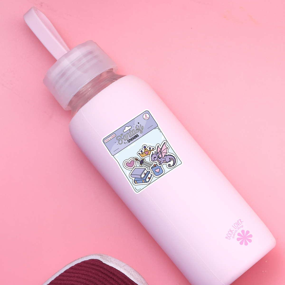 White bottle with colorful label on a pink background