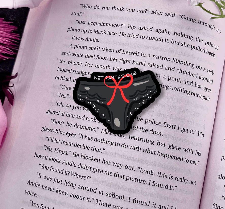 Black phone case with a red bow on an open book