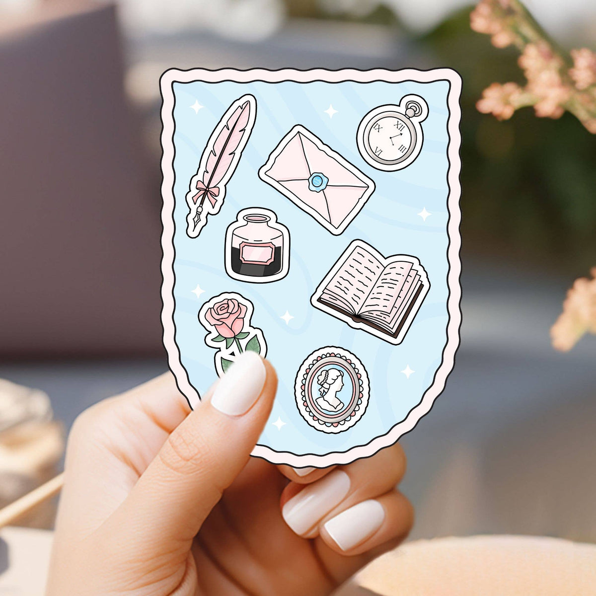 Hand holding a sheet of decorative stickers with literary-themed designs.