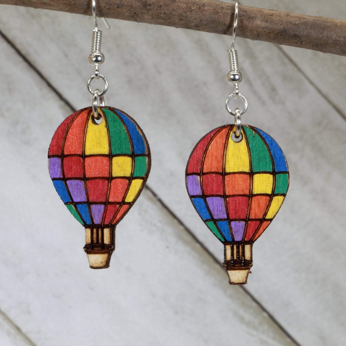 Hand-painted wooden rainbow hot air balloon dangle earrings with colorful travel-inspired design and hypoallergenic sterling silver hooks, whimsical adventure statement jewelry earrings for wanderlust lovers