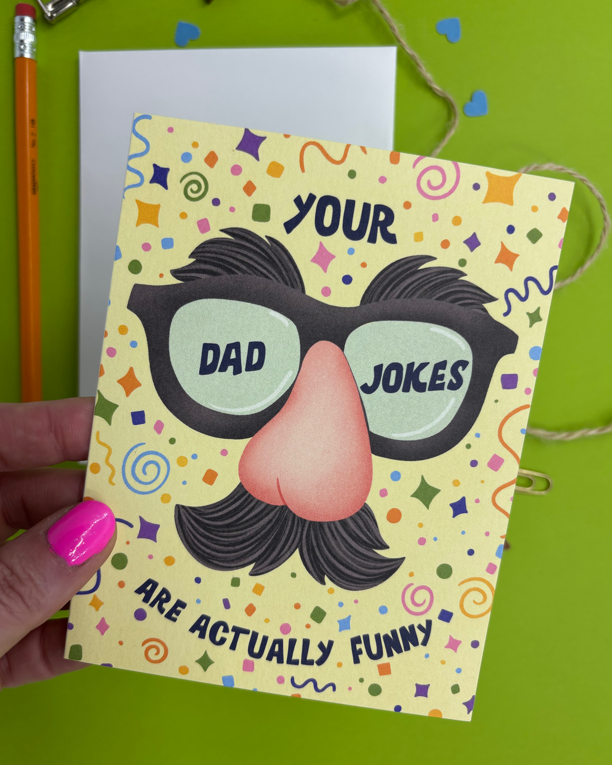 Card with a humorous design of glasses, mustache, and text on a green background