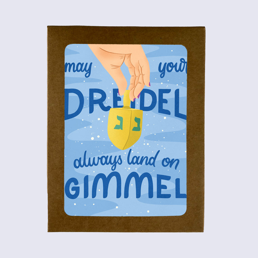 A greeting card with a blue background featuring text and an illustration of a dreidel, with the wish &