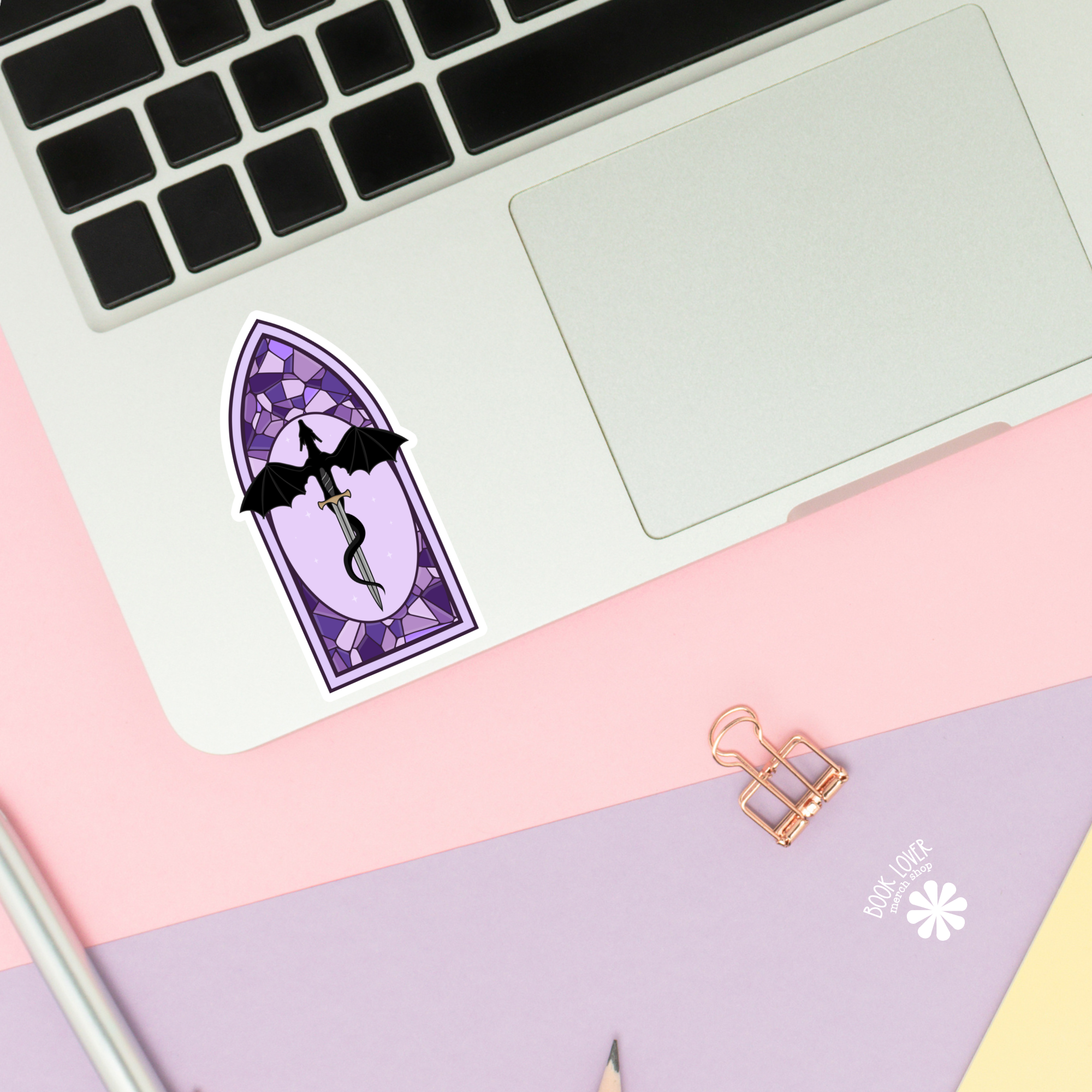 Purple stained glass-style sticker with a dragon on a laptop keyboard