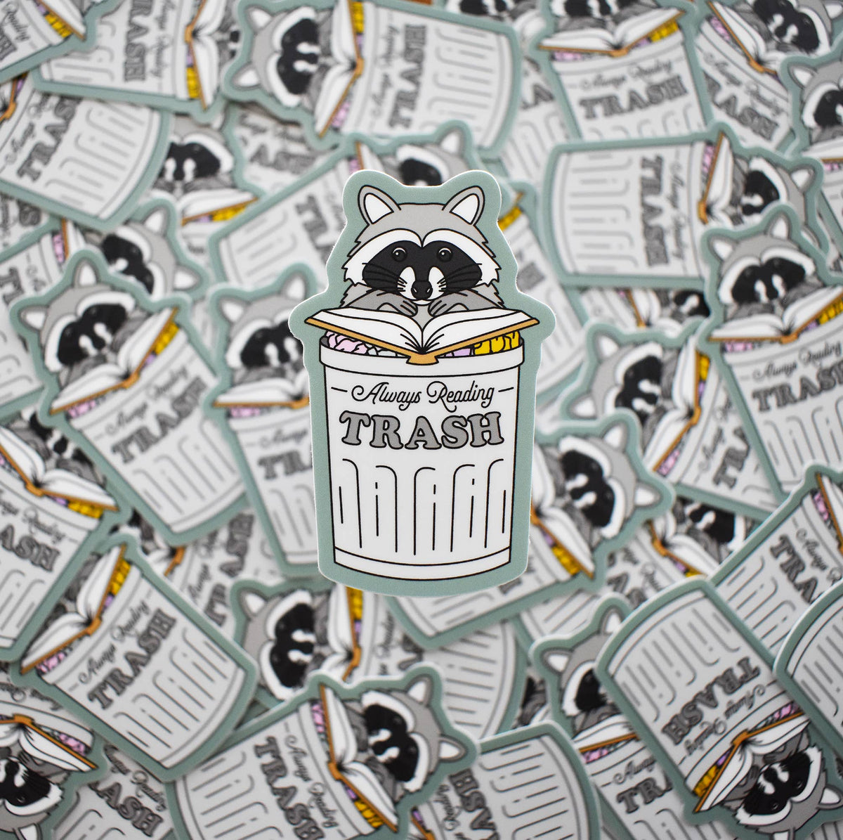 Sticker with a raccoon reading &