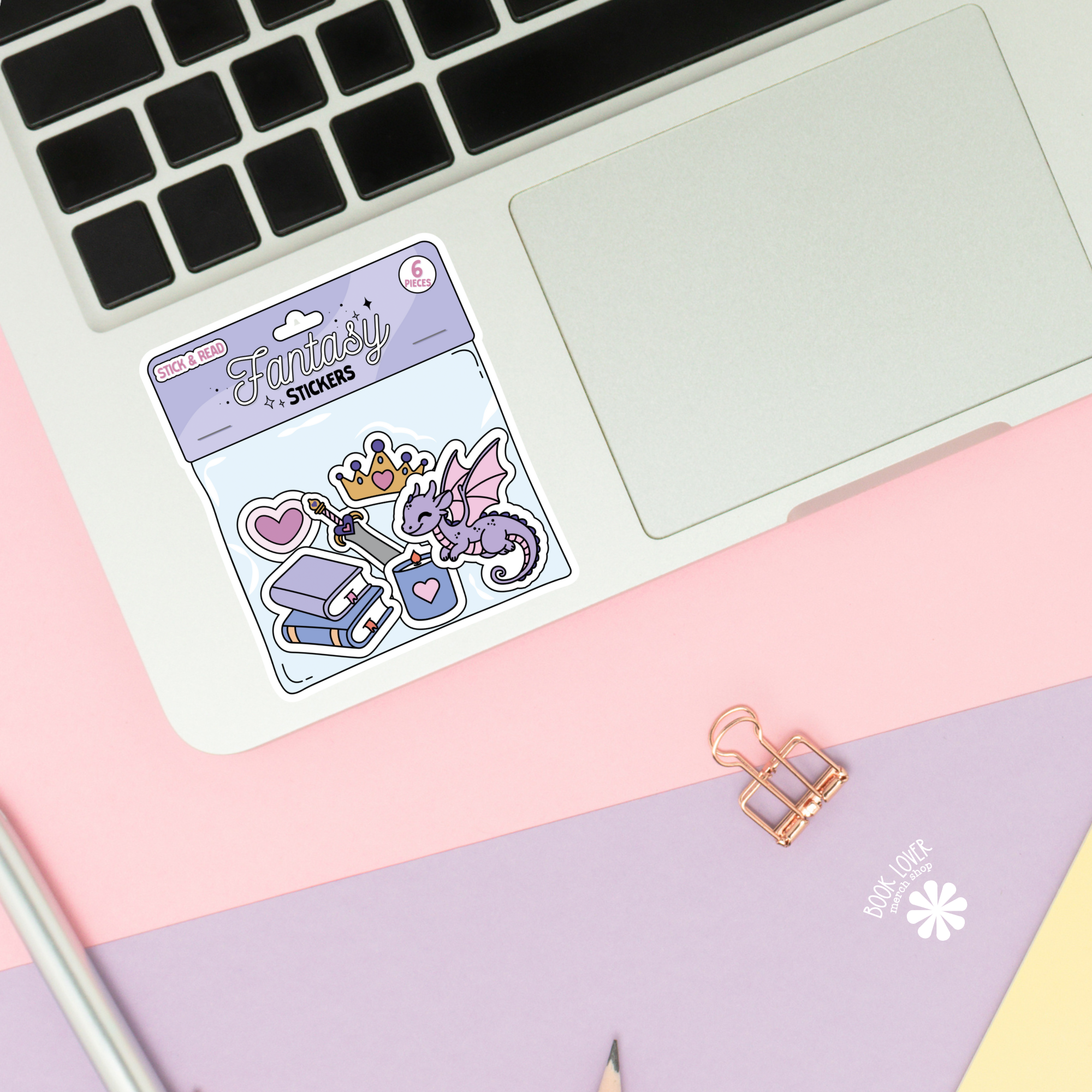 Pack of stickers with a purple dragon design on a laptop keyboard