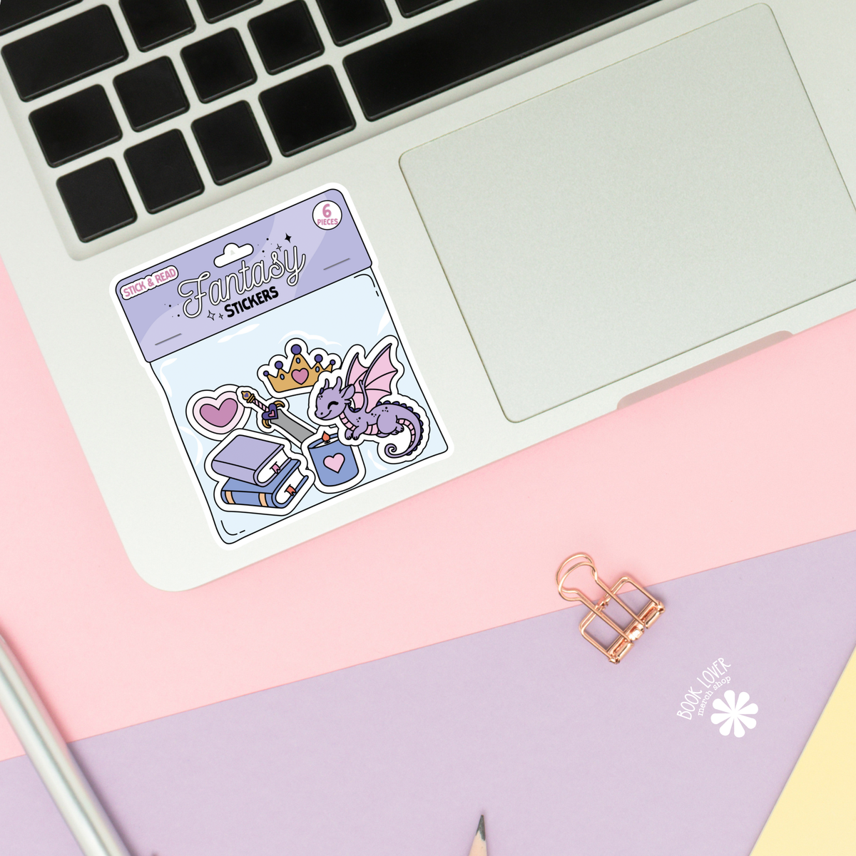 Pack of stickers with a purple dragon design on a laptop keyboard