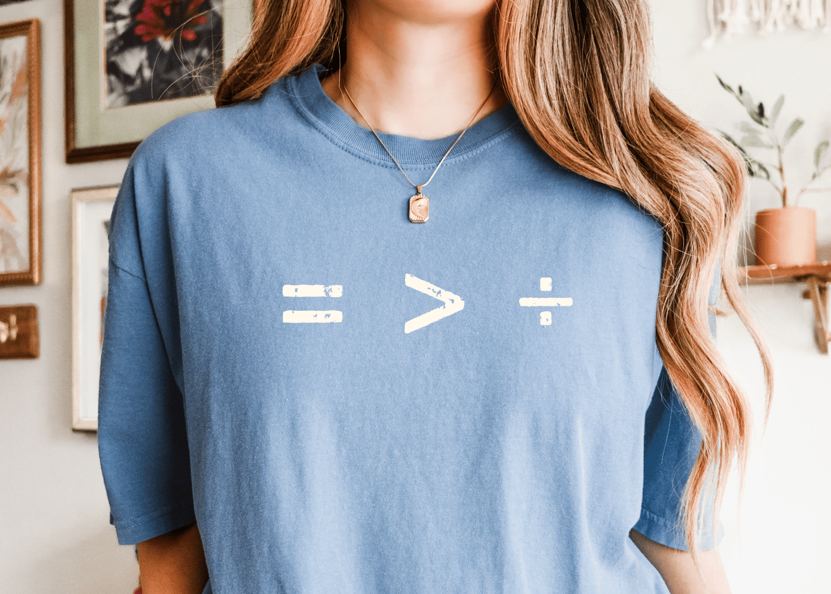 Person wearing a blue t-shirt with equation symbol of equality is greater than division
