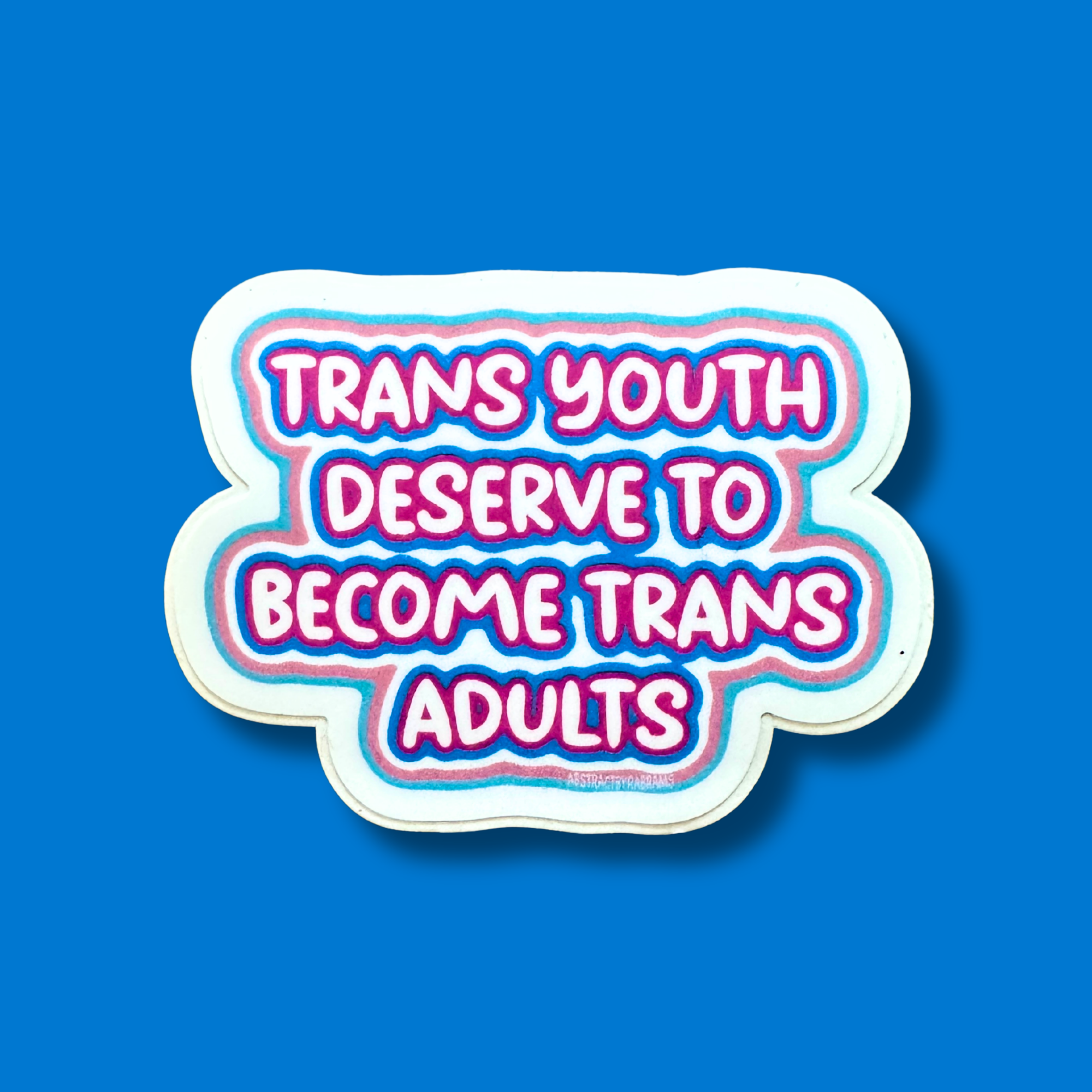 A die-cut sticker with the text &