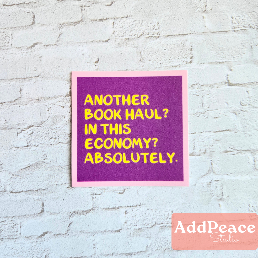 Purple sign with yellow text on a light blue brick wall, featuring the brand &