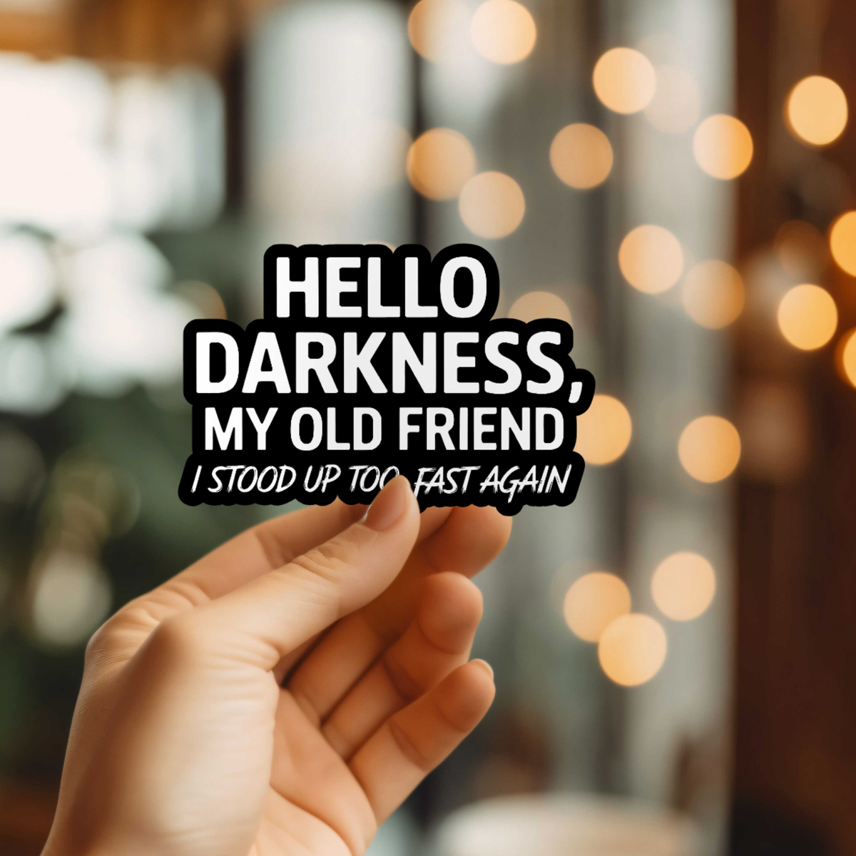 Hand holding a sign with text &