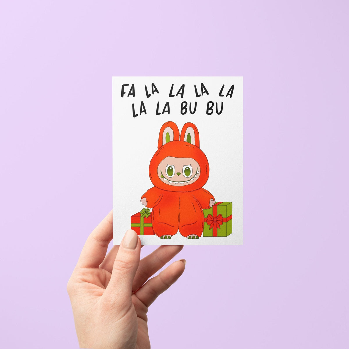 Fa La La Monster holiday card flat lay — cute illustrated monster Christmas card by indie artist MangoIllustrated