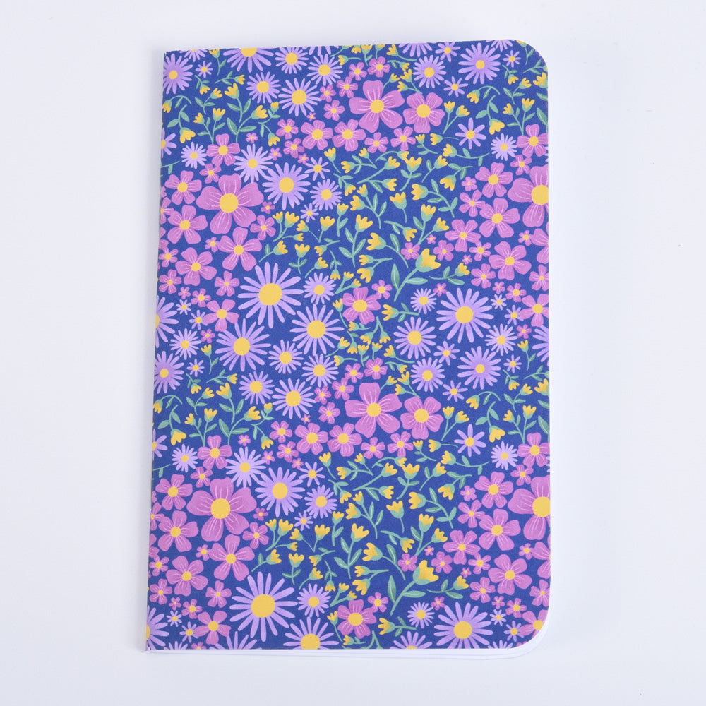 small pocket notebook featuring a floral design on dark blue background