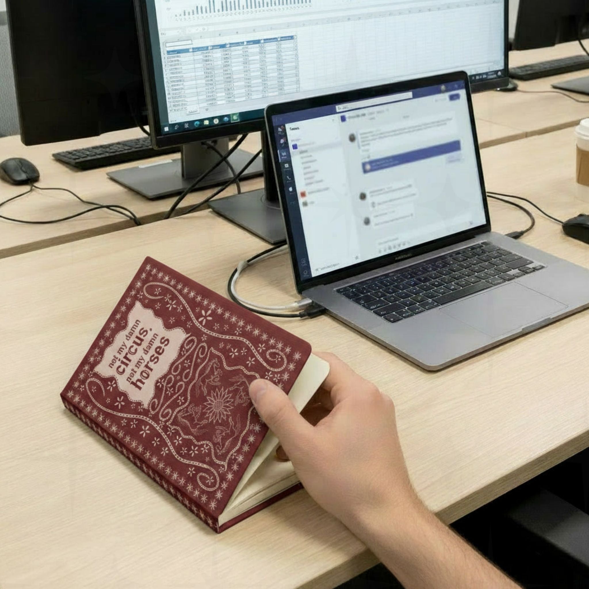 Person holding funny western snarky journal open at office desk with laptop and dual monitors showing the stitched leather front cover