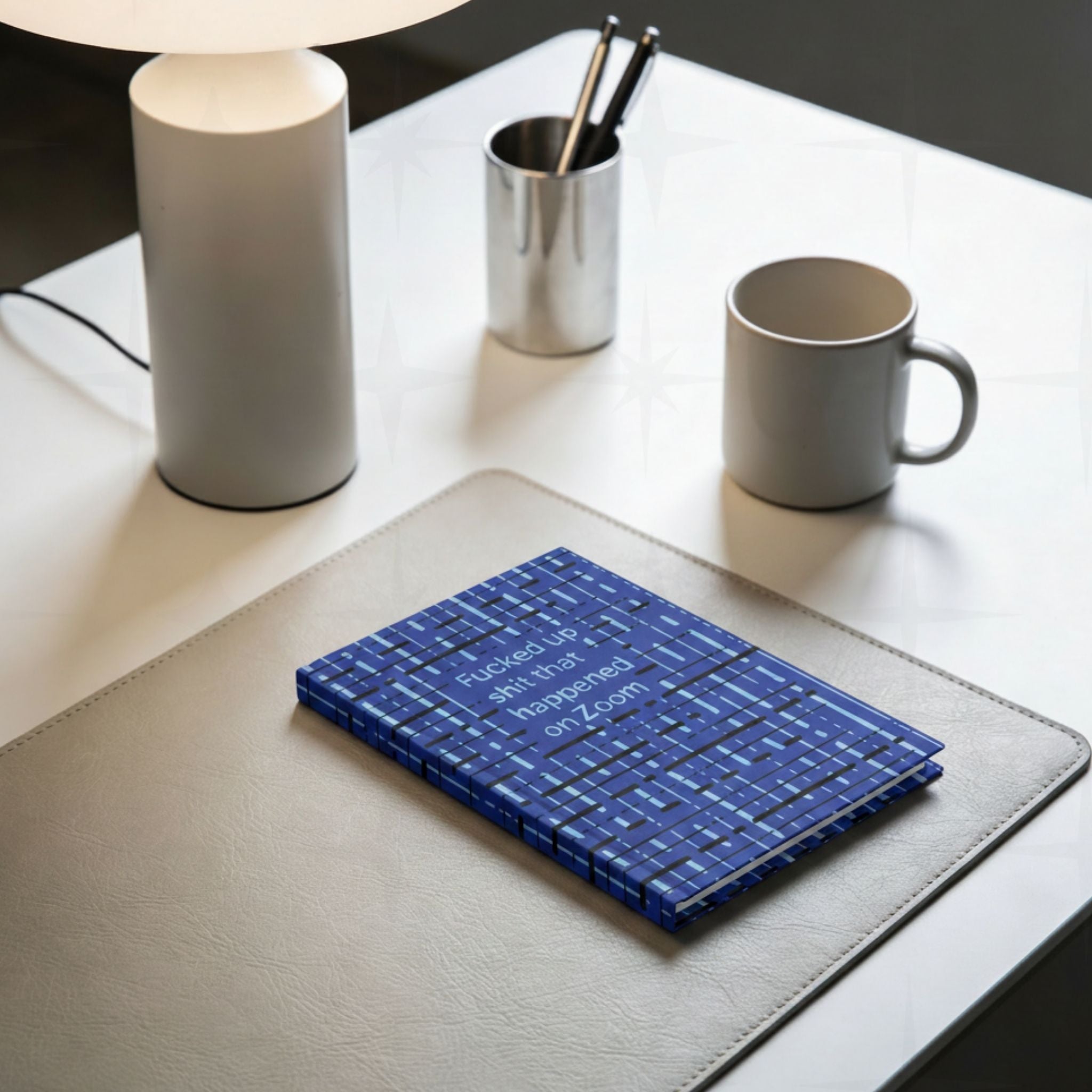 Funny Zoom profanity hardcover journal place on a desk mat next to cup of coffee