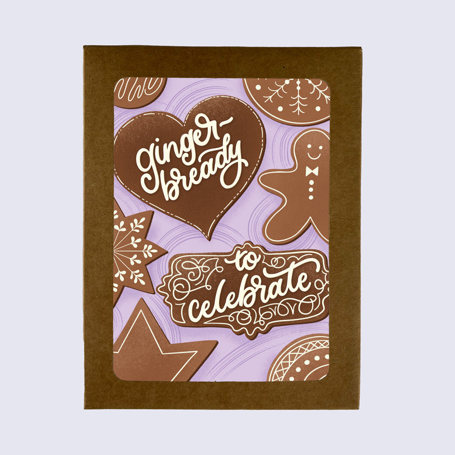 A greeting card with a gingerbread man design, along with stars, hearts, and text that reads &