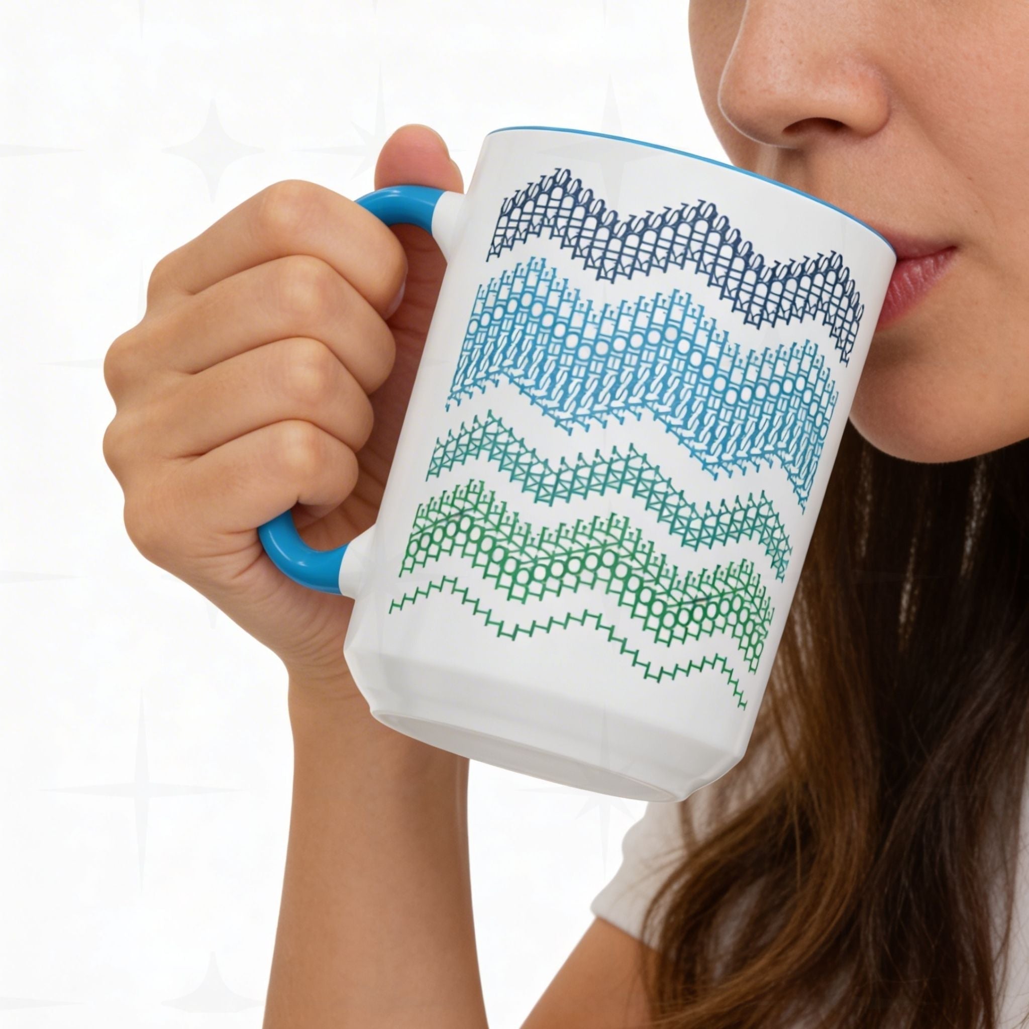Woman drinking from Ocean & Blue hidden message mug 15oz against white tile — close-up showing the navy, blue, teal, and green typographic chevron wave pattern