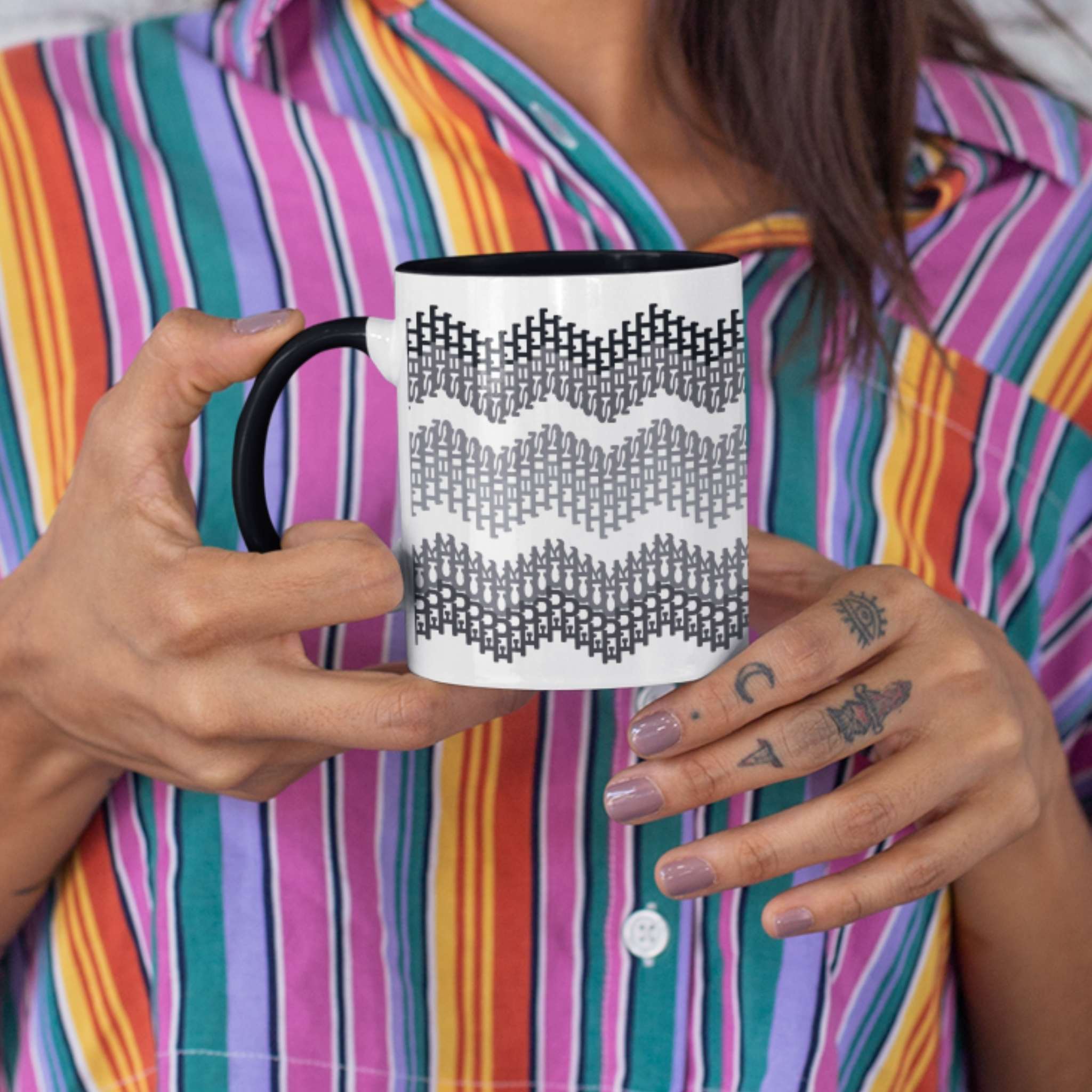 Woman in colorful striped shirt holding 11oz hidden profanity accent mug with gray chevron swear word pattern