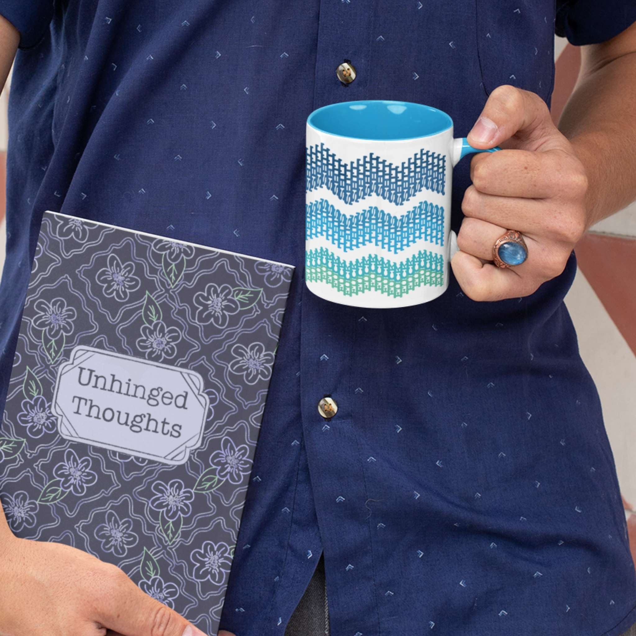 Person holding 11oz ocean ombre hidden profanity accent mug alongside Unhinged Thoughts journal with floral cover