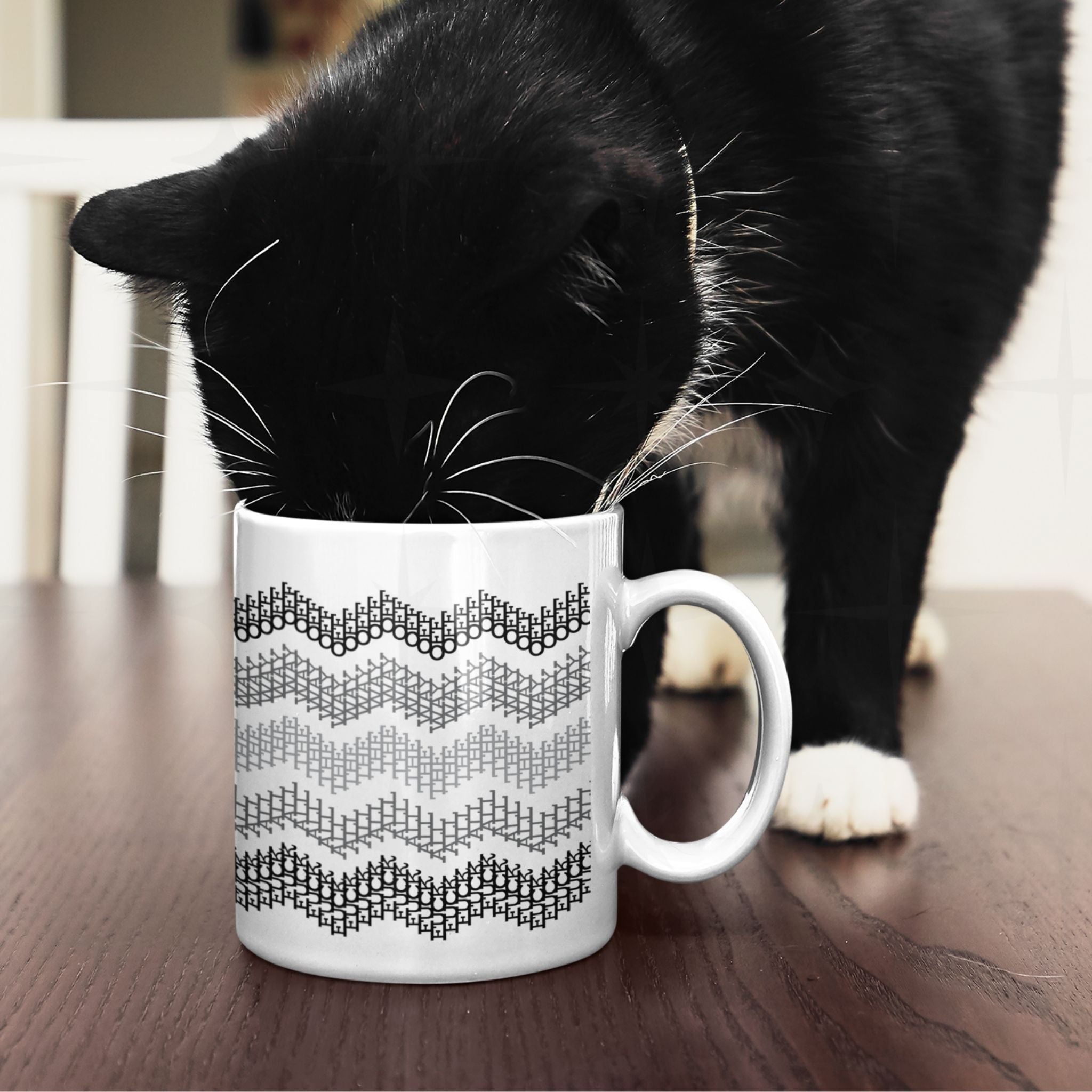 Black and white tuxedo cat investigating gray stripes hidden profanity chevron mug on dark wood table