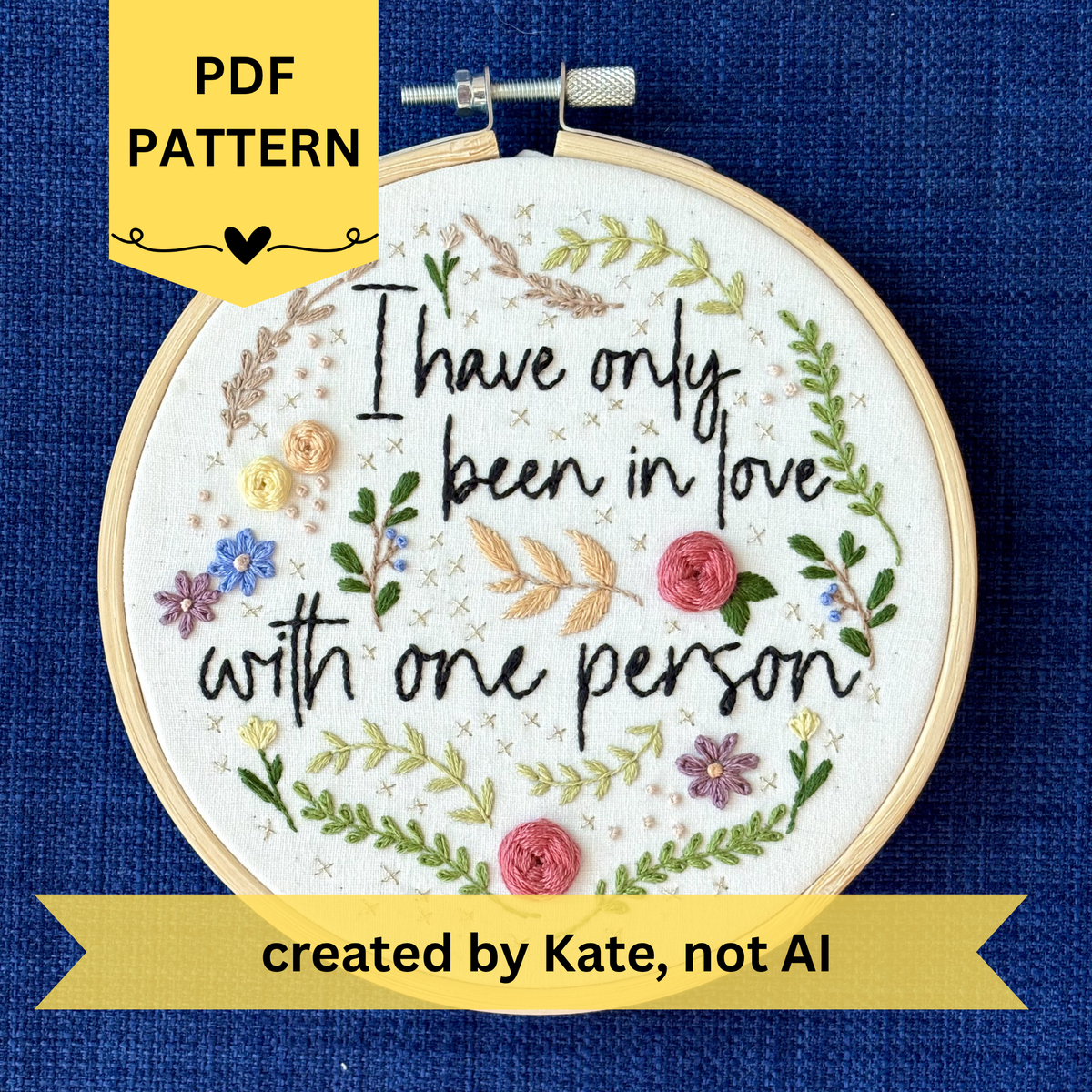 PDF pattern created by Kate, not AI. "I have only been in love with one person." Quote hand embroidered in handwriting font in black embroidery floss. Surrounding the text are vines and flowers and plants in shades of green, light browns, peach, pink, periwinkle blue, and dusky purple. Background is filled with pink dots and metallic gold Xs. Sewn on white cotton. Framed as wall art in a light wood embroidery hoop.