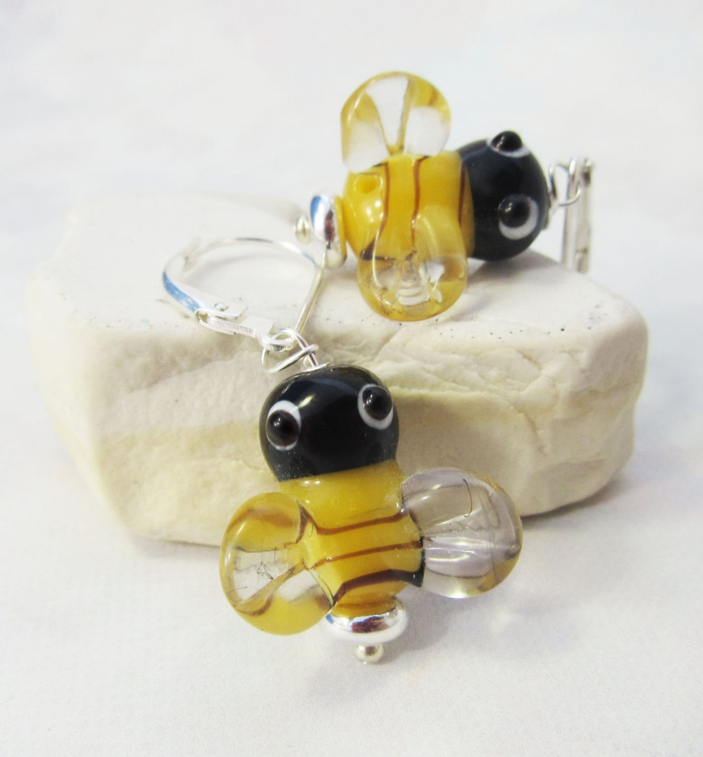 Glass Honeybee Earrings – Pollinator Jewelry – Gift for Gardeners & Nature Lovers: features yellow and black stripes, clear wings, and black eyes; perfect nature-inspired earrings displayed on a light stone.