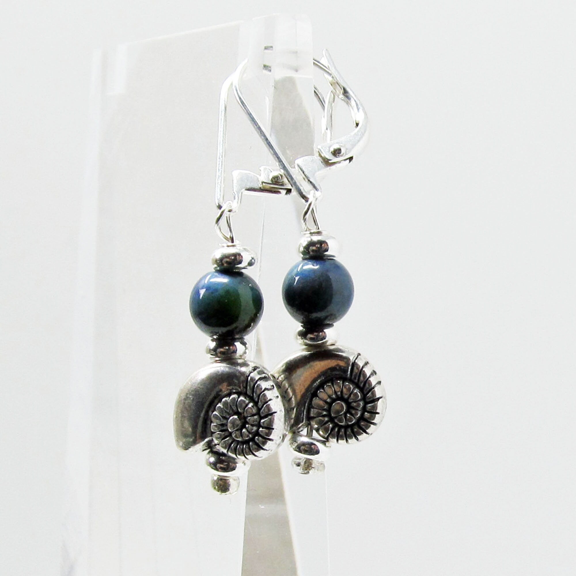 Model wearing SEA SHELL EARRINGS - Silver Shell Earring dangles, highlighting their bohemian style and versatility with various outfits.