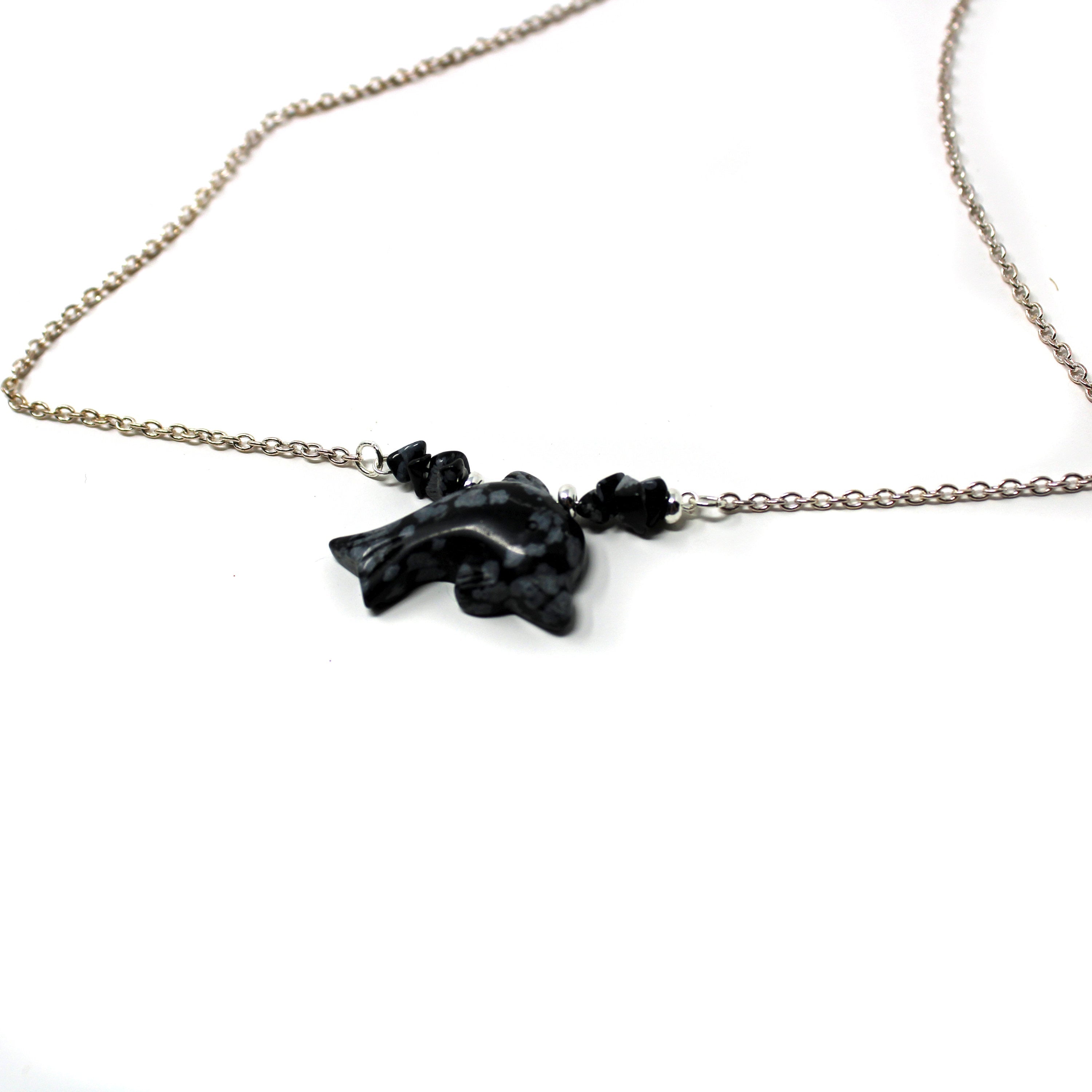 Close-up view of snowflake obsidian dolphin choker - unique jewelry for dolphin lovers.
