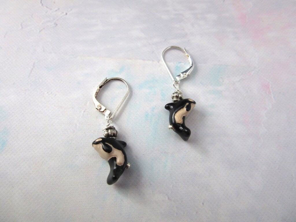 Hand Painted Orca Whale Earrings - Sterling Silver Lever Backs featuring small, hand painted black and white orca charms against a light, textured background.