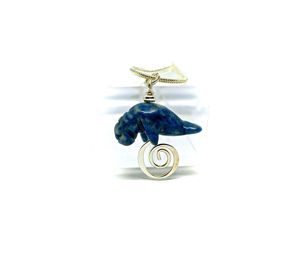Close-up of the unique carved sodalite Manatee Blue Necklace, showcasing the beautiful mild blue swirls, ideal for ocean lovers and handmade jewelry fans.