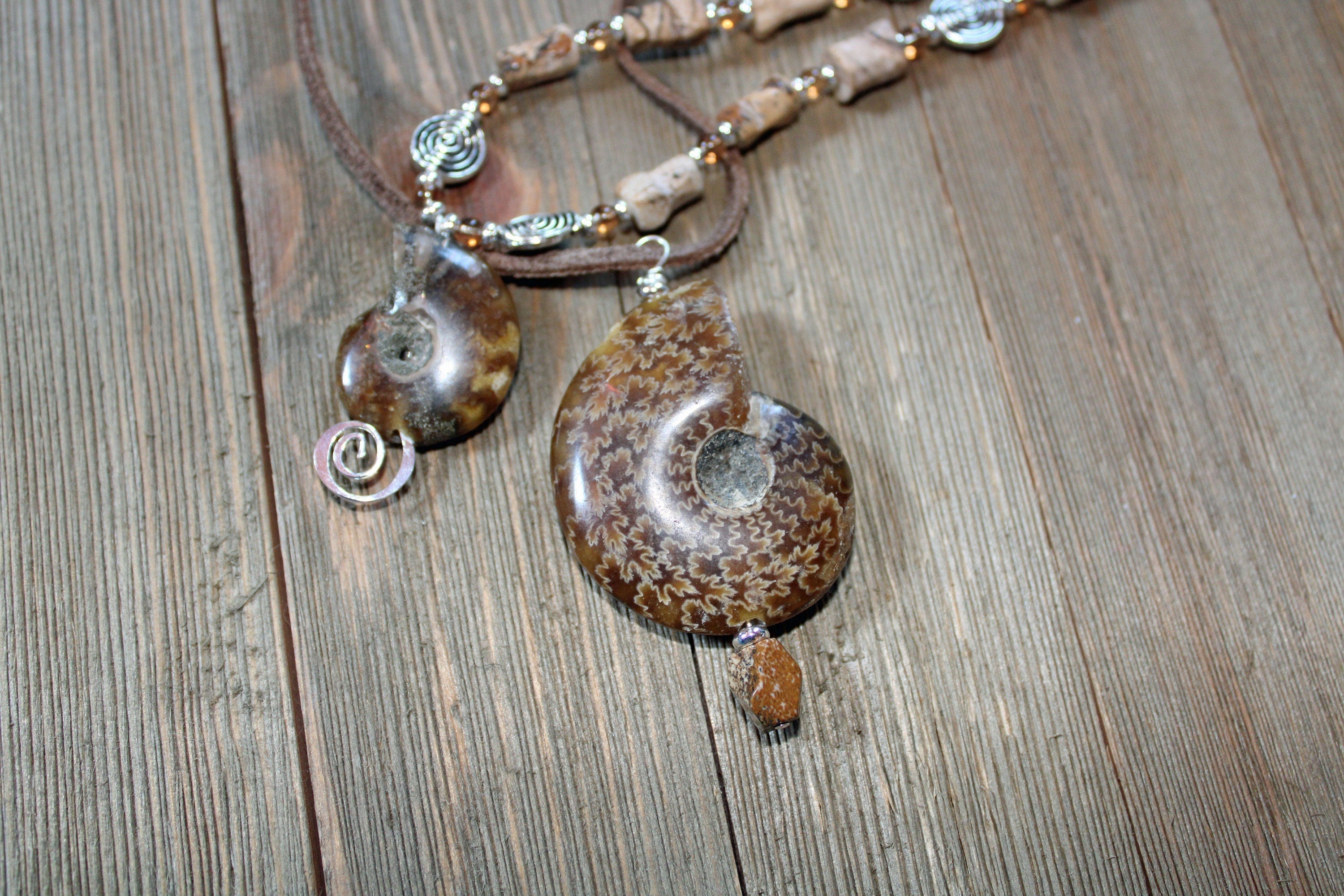 Ammonite fossil partner jewelry necklace set featuring an inch and a half pendant with opalescent bands.