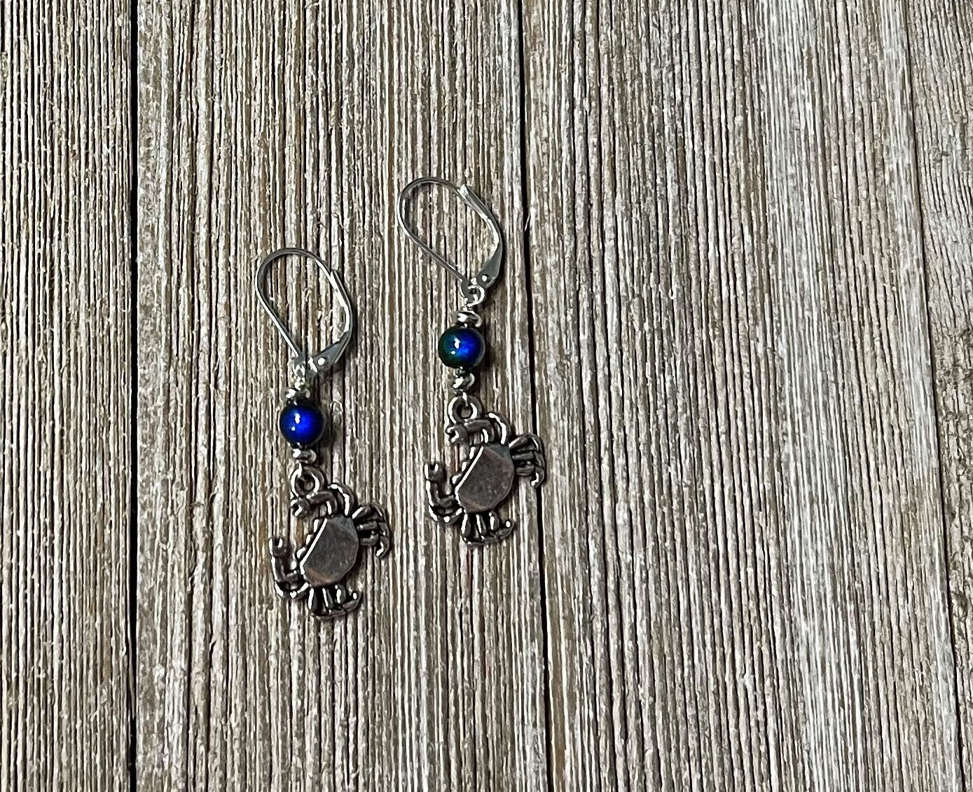 Crab Dangle Earrings – Color Changing Mood Bead, the perfect ocean lover gift, displayed on a rustic wooden surface.