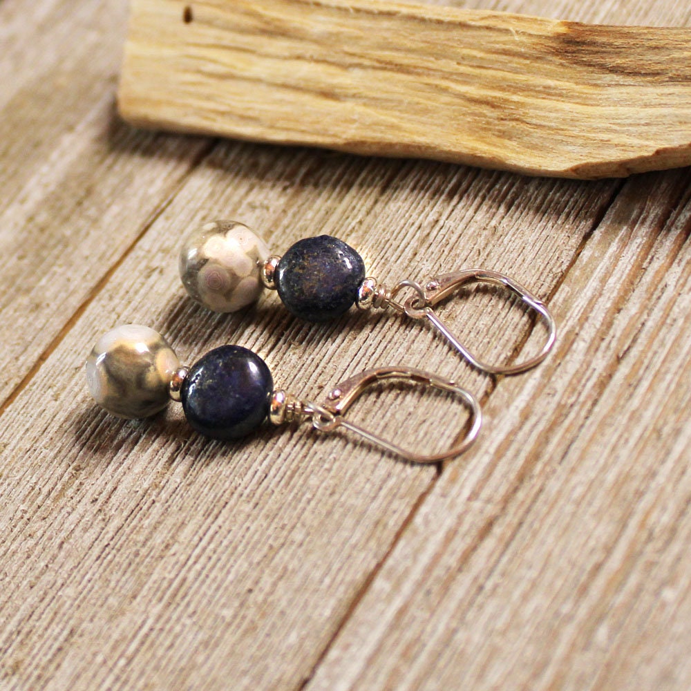 Elevate Your Everyday Elegance with Lapis Lazuli Sterling Silver Earrings featuring a blue lapis lazuli bead and a patterned grey bead on leverback hooks.