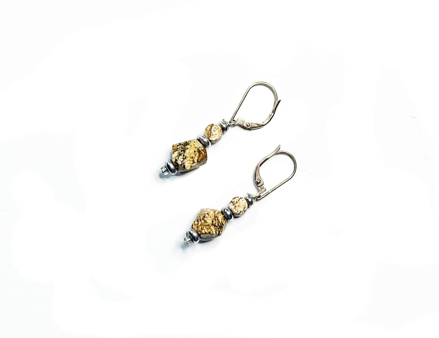 The Handcrafted Jasper Earrings feature sterling silver lever-back clasps and textured gold and silver beads for a geometric Zen look, beautifully presented on a white background.