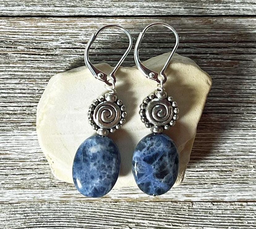 Sodalite earrings - artisan-designed stone and spiral, denim blue earrings. Close-up view highlighting intricate blue swirls and sterling silver accents.