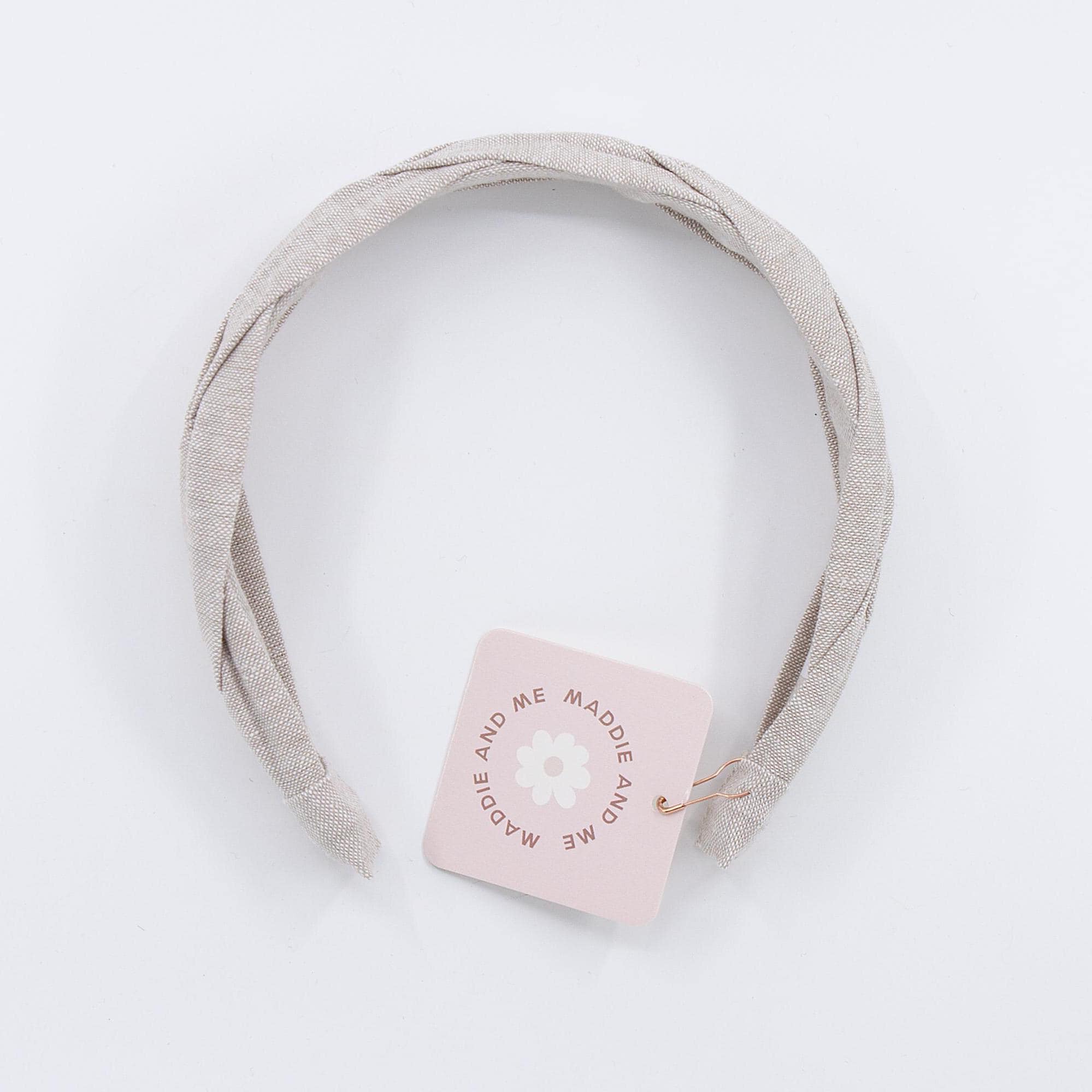 A light tan braided linen headband. The headband has a tag that says "MADDIE AND ME".