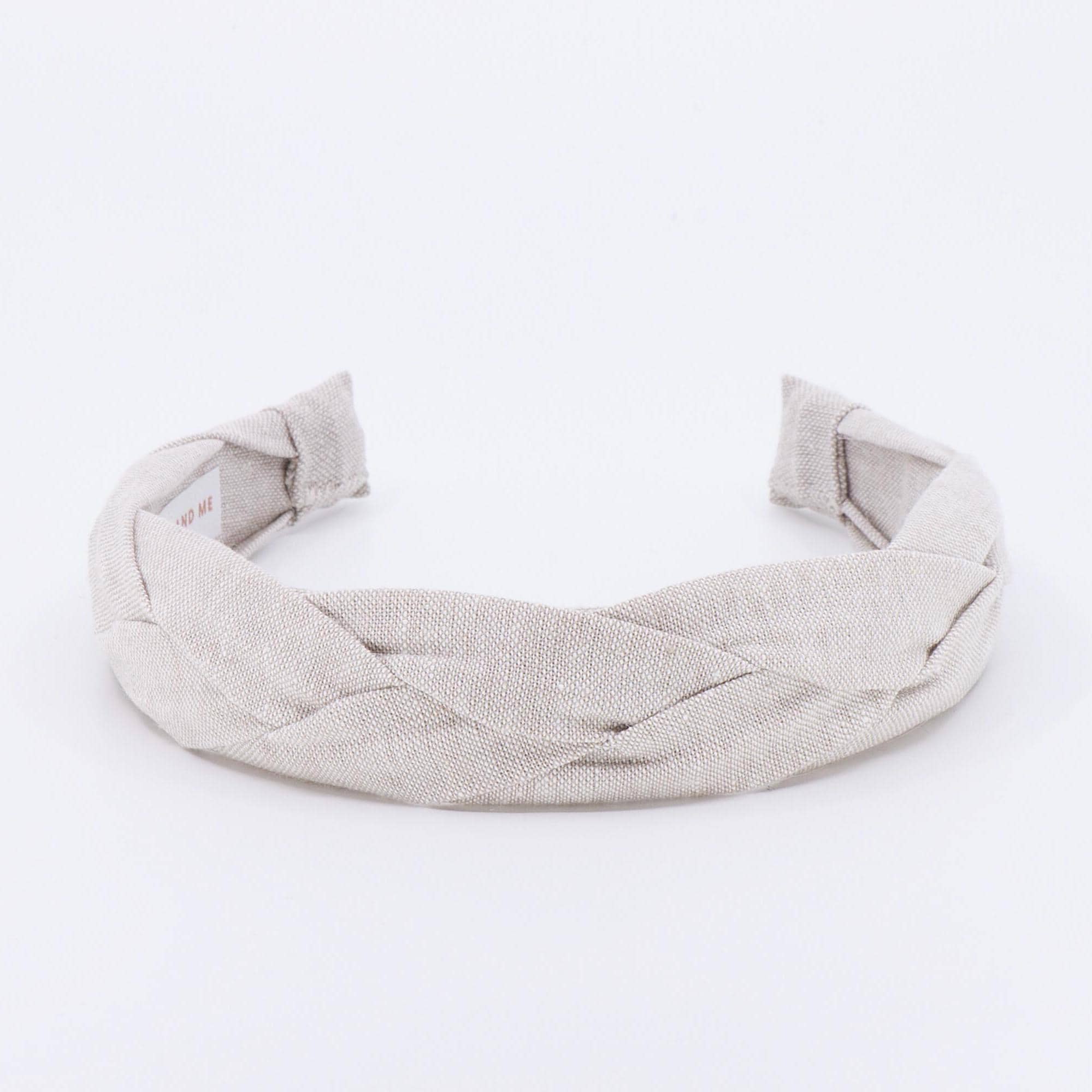 A light tan braided linen headband.