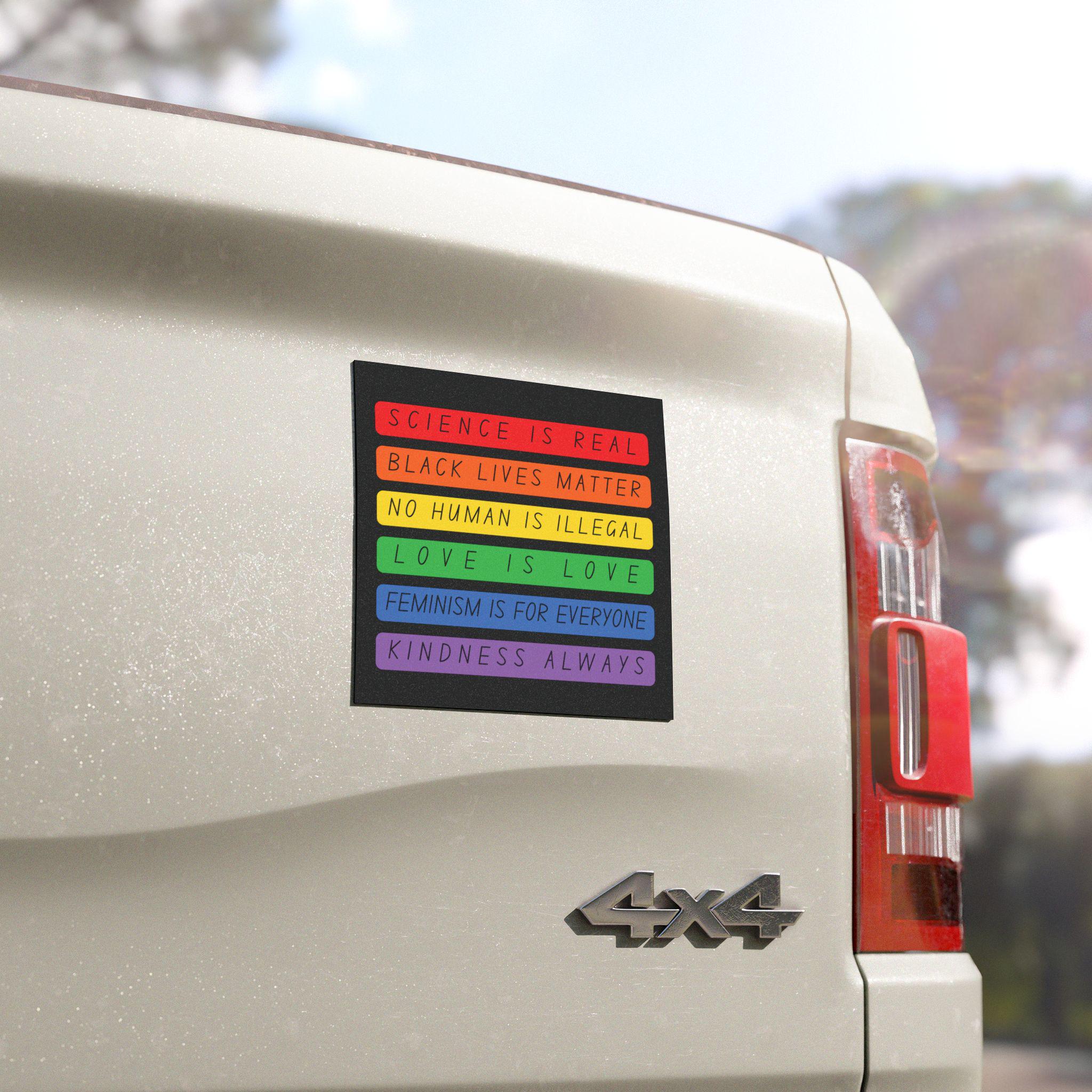 Square bumper magnet in rainbow blocks reading “Science is Real, Black Lives Matter, No Human is Illegal, Love is Love, Feminism is for Everyone, Kindness Always”