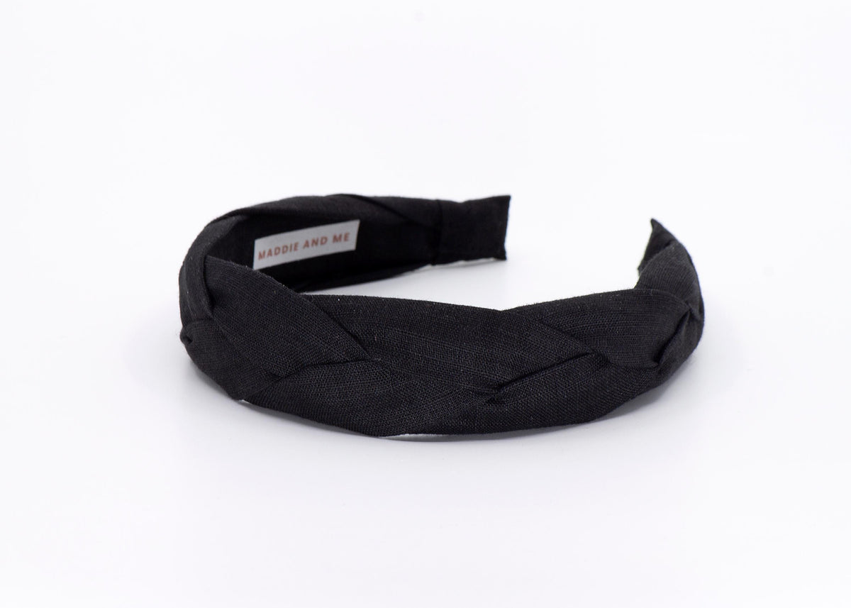 May include: A black braided headband made of fabric.